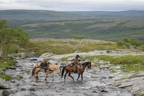 Two riders crossing a river on the plateau
