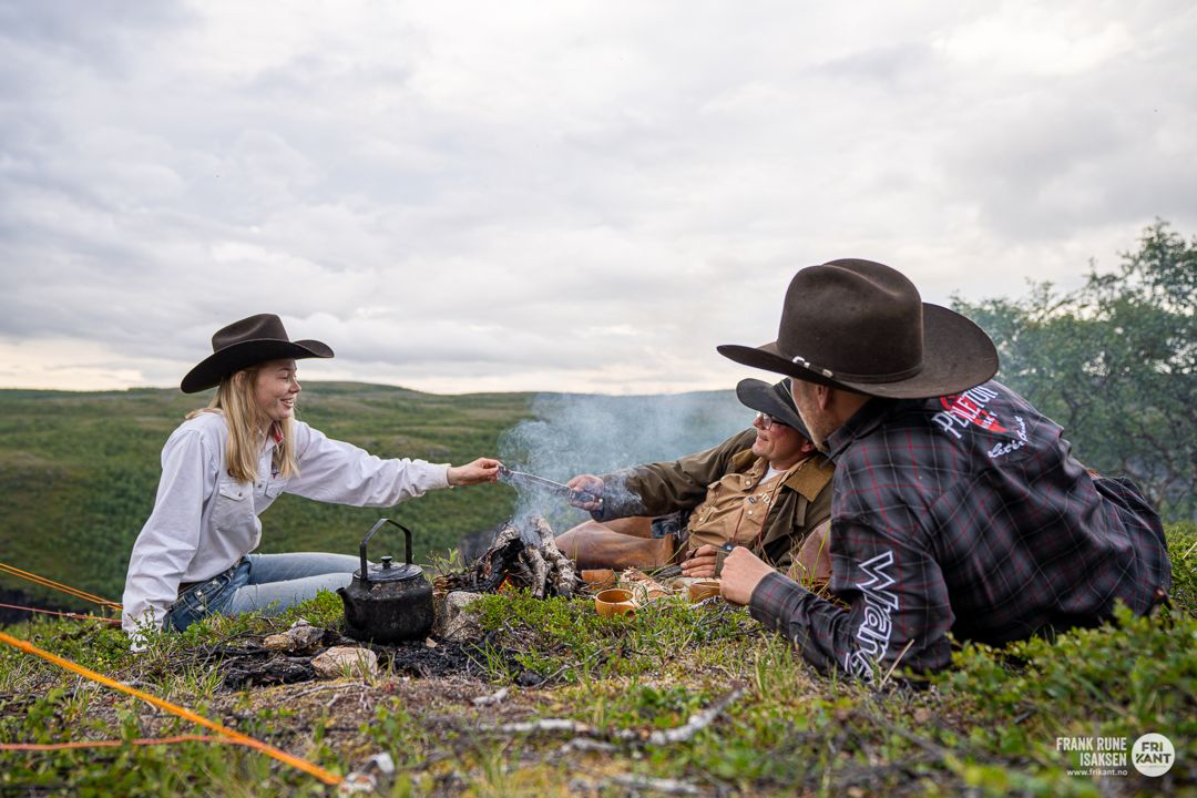 Riders sharing coffee around a campfire on the plateau